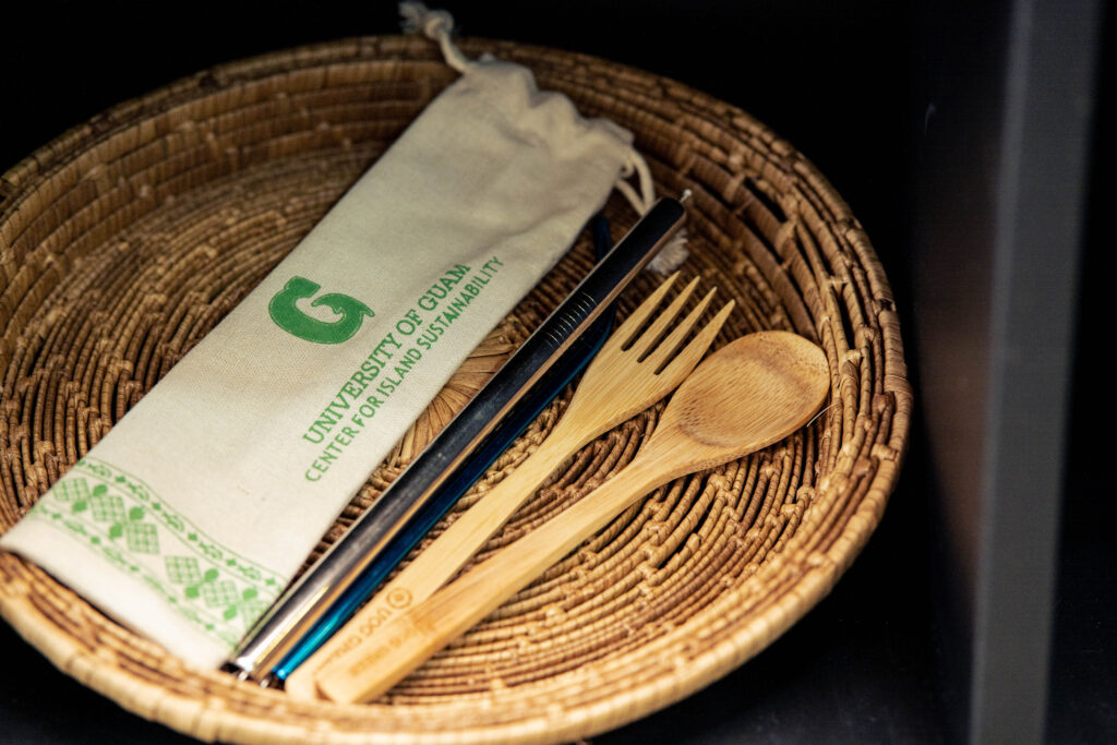 A set of reusable wooden utensils and metal straws is displayed in the Guam Green Growth Circular Economy Makerspace and Innovation Hub storefront at the CHamoru Village in Hagåtña, Guam. The store offers various local products for environmentally conscious consumers and encourages sustainable living.