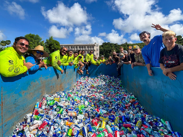 G3CC lean over edges of bright blue container filled with thousands of crushed aluminum cans
