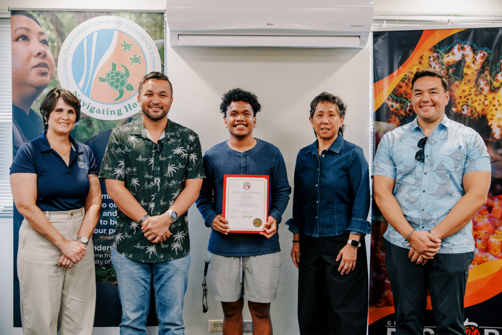 Azer Bilimon, a student in the UOG School of Engineering who received the Native American/Indigenous Student Research Abstract Award at the 2025 SACNAS Conference, receives a certificate from Sen. Vincent A.V. Borja, chair of the Legislature’s Committee on Education.