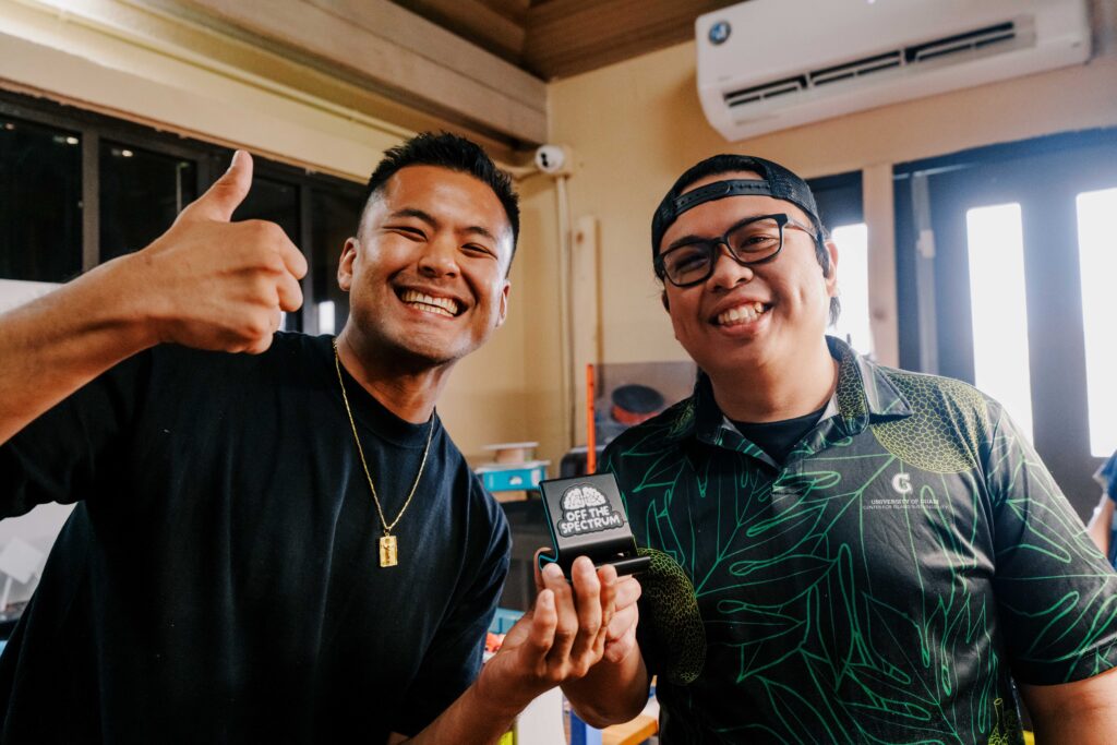 Off The Spectrum co-organizer Anthony Cruz, left, and G3 Makerspace’s Shawn Garcia, right, hold a phone stand designed by Garcia for participants of the “Walk Different” event on Saturday, Oct.10.